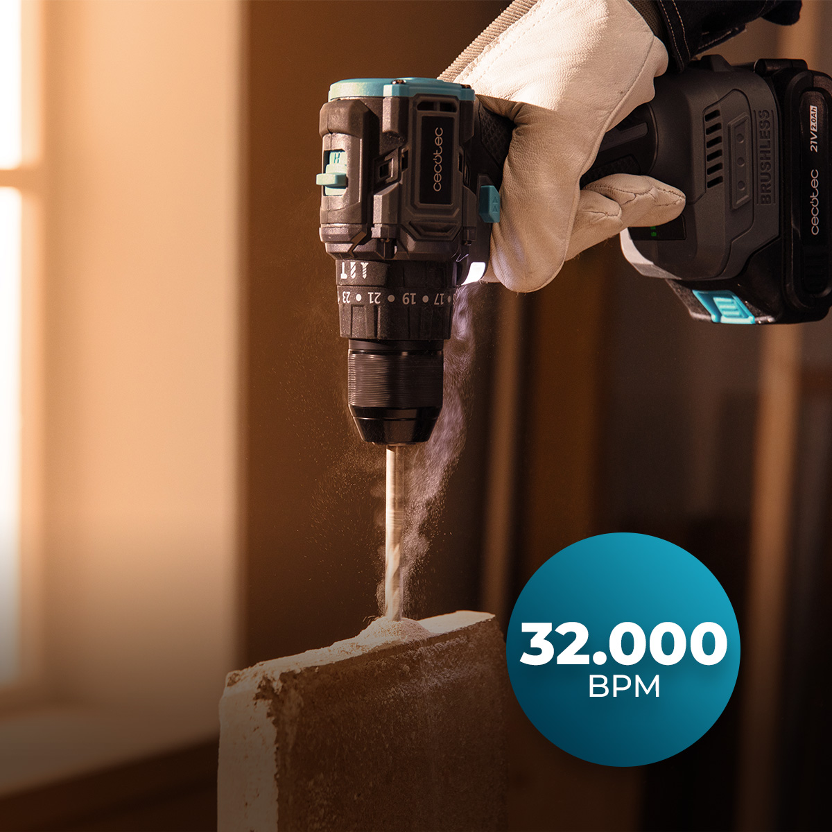 Una mano enguantada usa un taladro inalámbrico en un bloque de piedra, produciendo polvo, con la etiqueta 32,000 BPM.