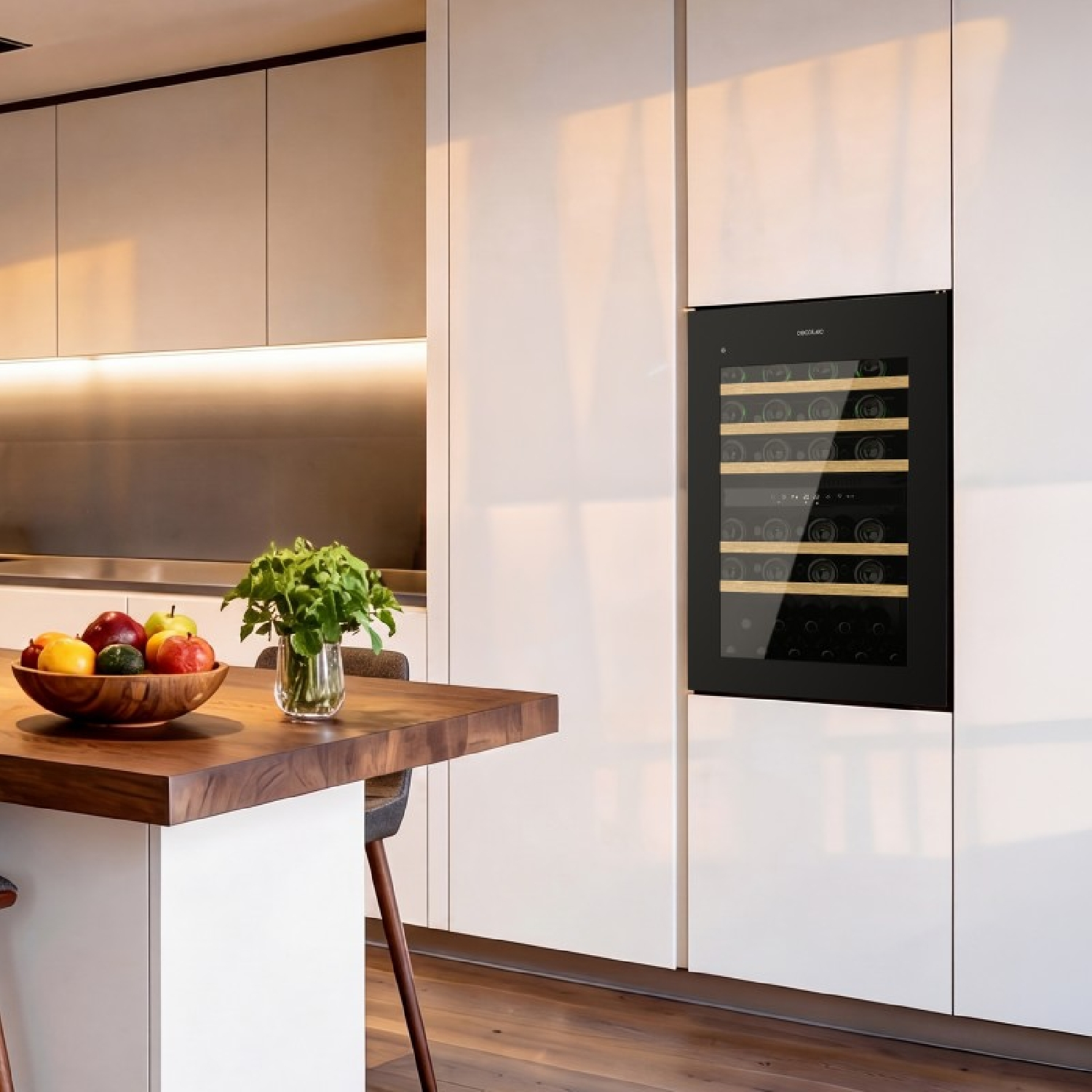 Una cucina moderna con cantinetta integrata, isola in legno con fruttiera e pensili illuminati.