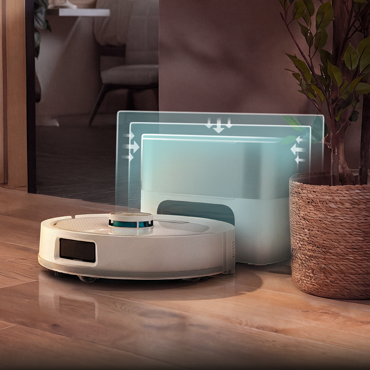 Un robot aspirador blanco está sobre un suelo de madera cerca de su base de carga y una planta en maceta.