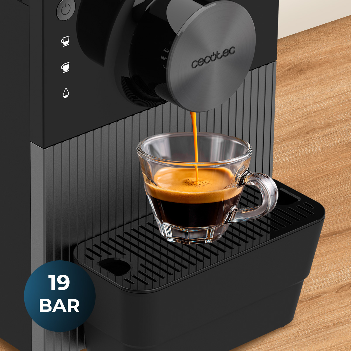 Una macchina da caffè nera Cecotec versa espresso fresco in una tazza di vetro su un tavolo di legno.
