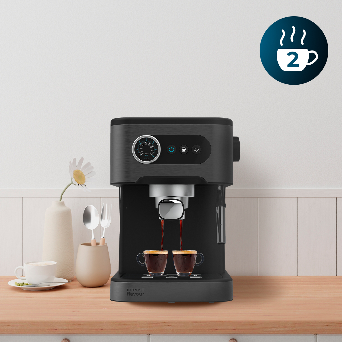 Una cafetera negra sobre una encimera de madera vierte café en dos tazas de cristal simultáneamente.