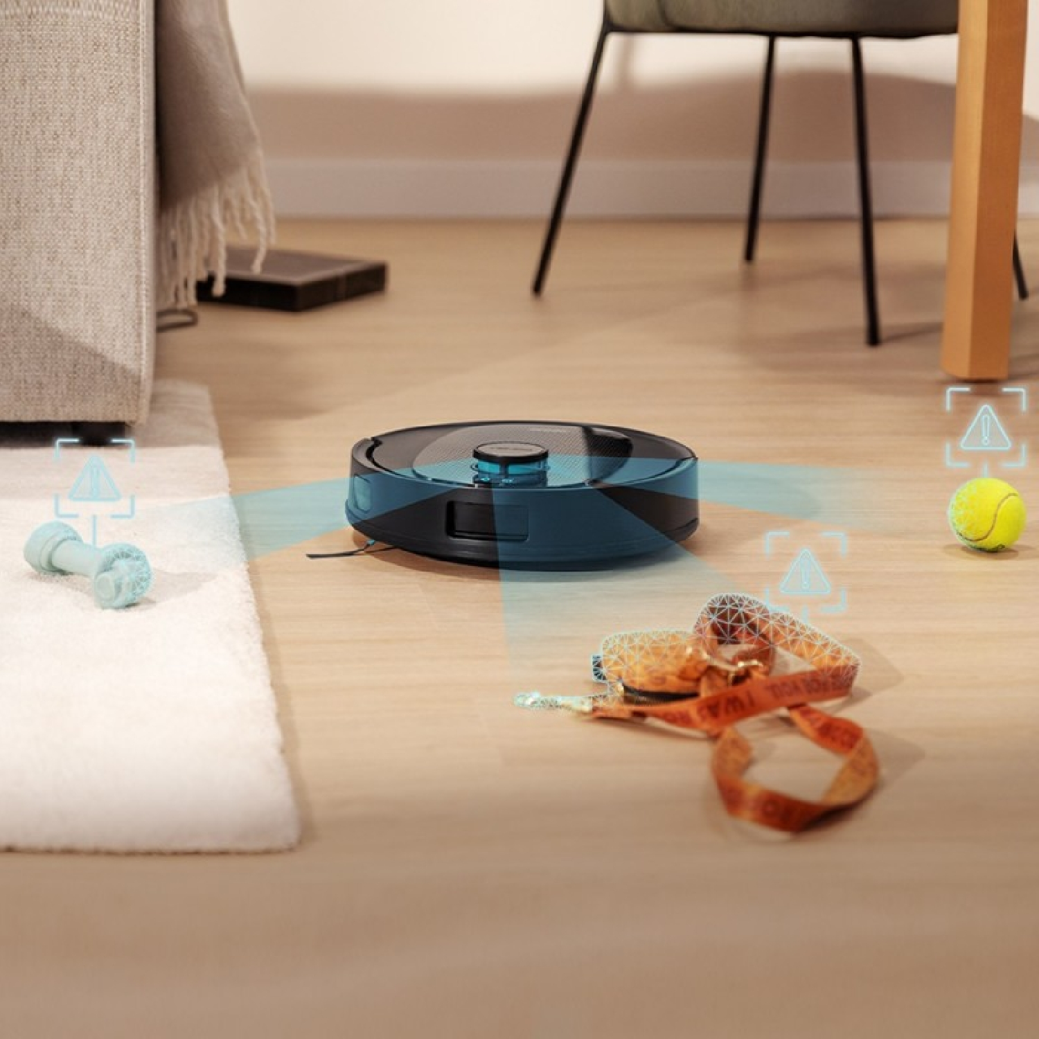 Un robot aspirapolvere scansiona oggetti come un gioco per cani e una pallina sul pavimento in legno di un soggiorno.