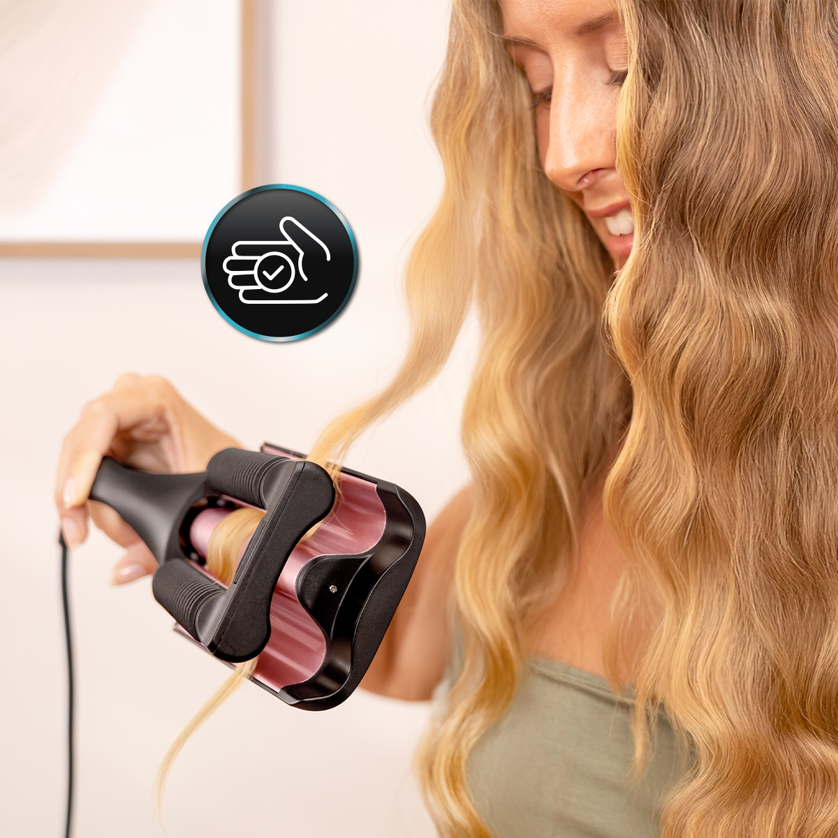 Una donna arriccia i suoi lunghi capelli biondi con un ferro rosa e nero.