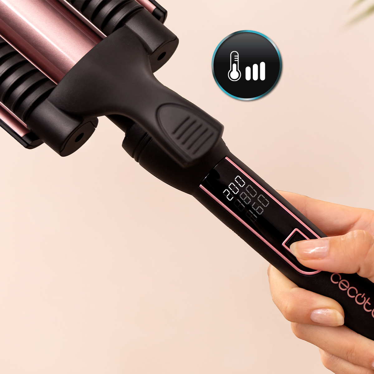 Una mano tiene un ferro arricciacapelli nero e rosa con display digitale.