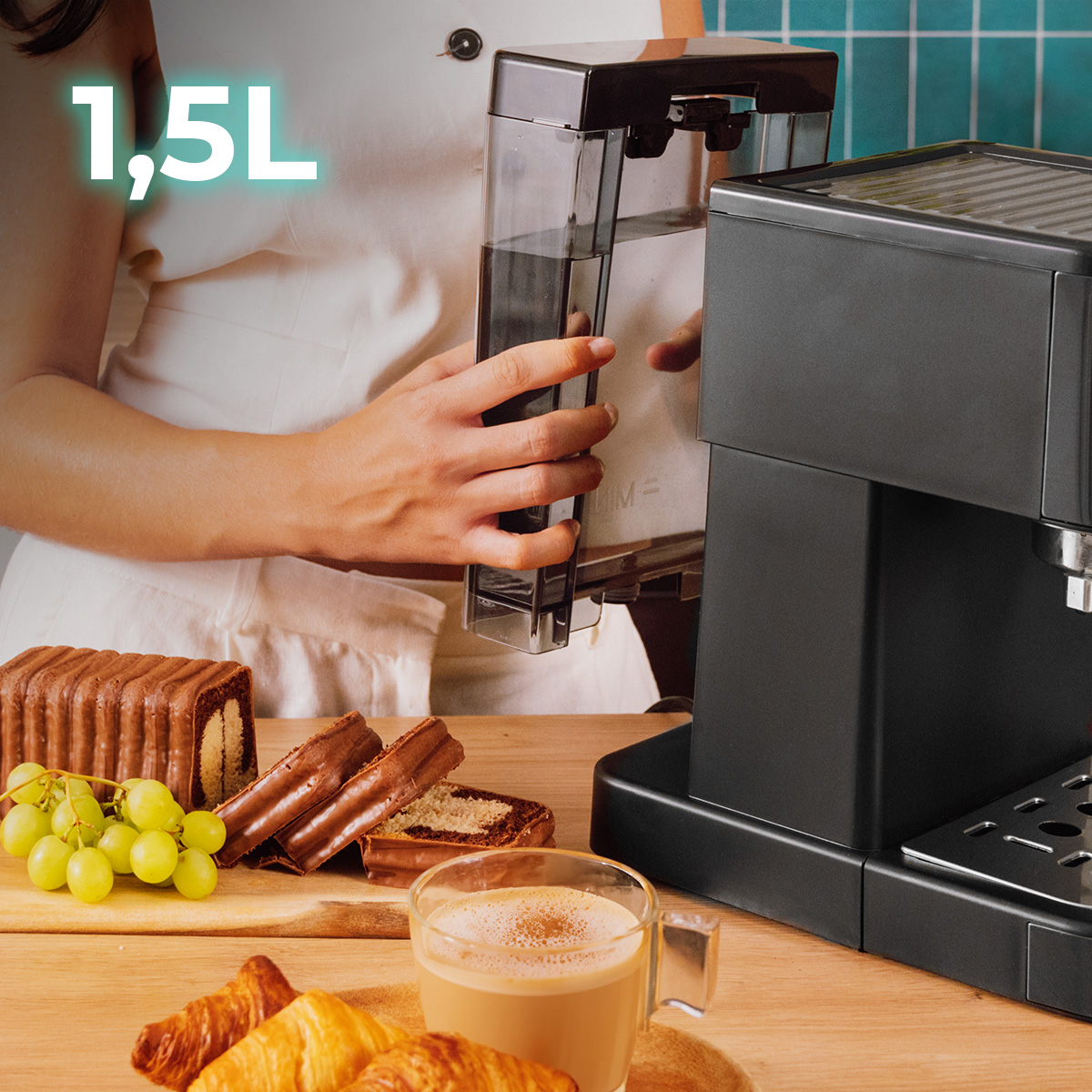 Una donna riempie il serbatoio dell'acqua di una macchina da caffè nera; torta, uva e caffè.