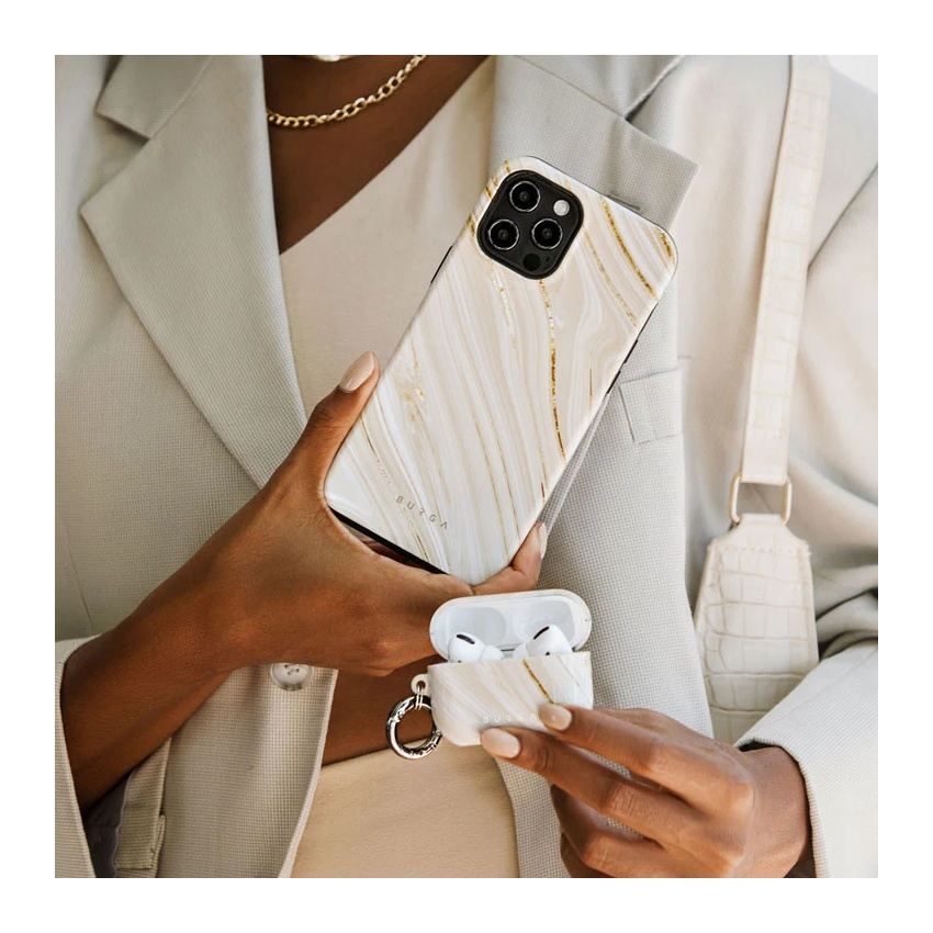 A person in a light suit holds a phone and AirPods case with a white marble and gold pattern.