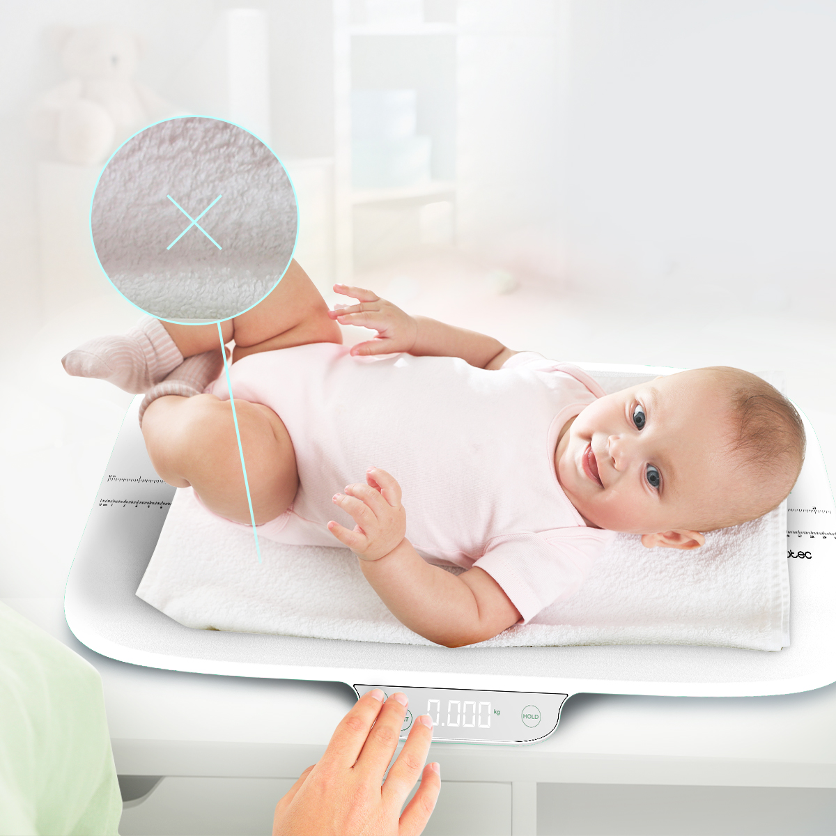Un bambino felice giace su una bilancia digitale, uno zoom evidenzia la morbida superficie.