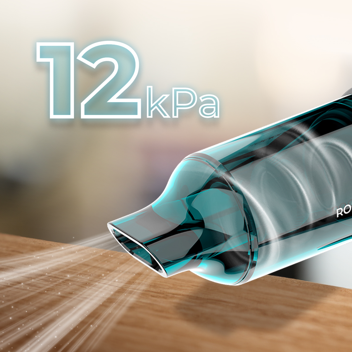 Un aspirapolvere portatile fluttua sopra un tavolo di legno, con la scritta 12 kPa.