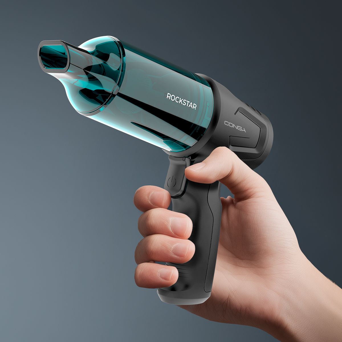 Una mano regge un aspirapolvere portatile nero con contenitore blu trasparente su sfondo grigio.