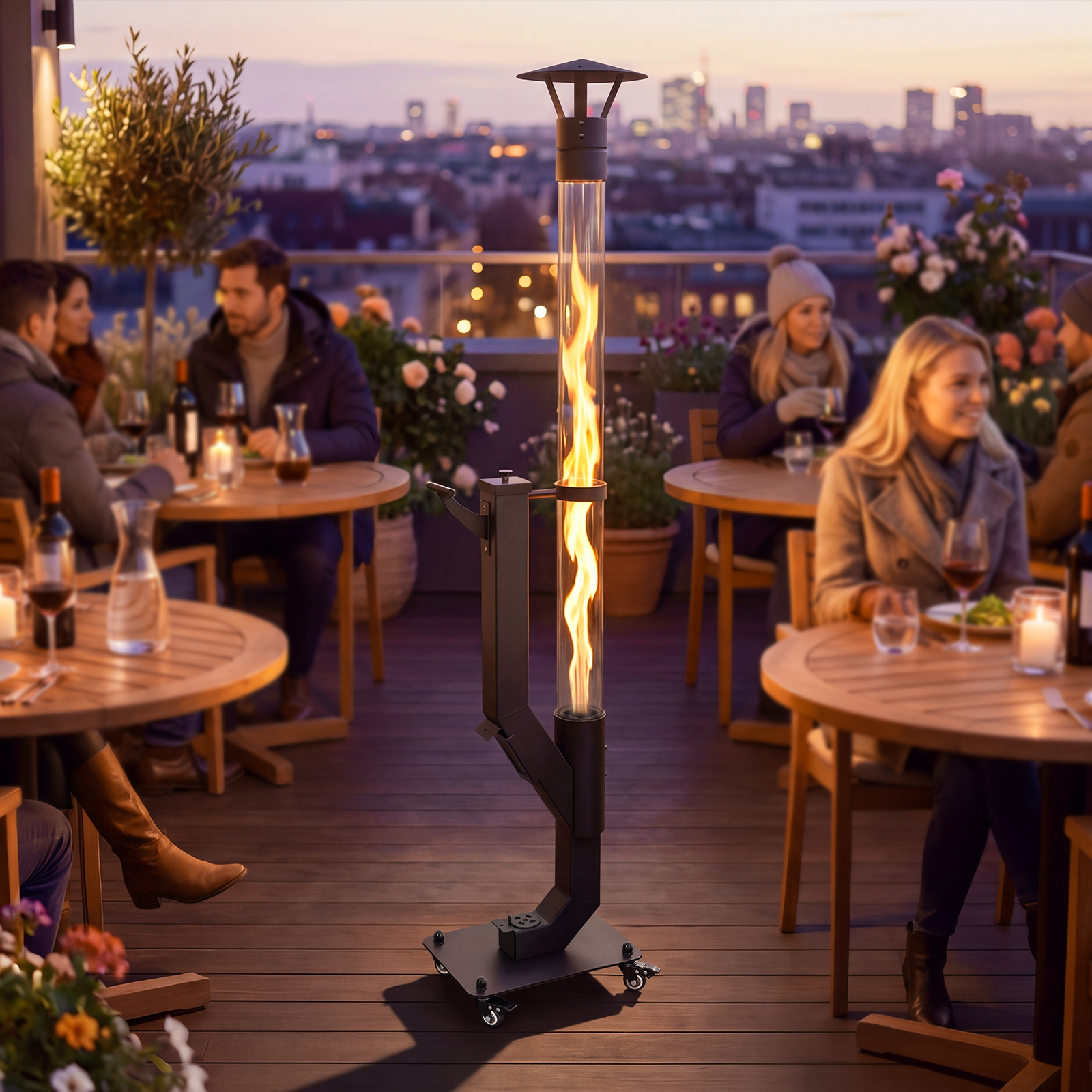 Un riscaldatore da patio allungato con fiamma viva in un tubo di vetro si trova su una terrazza sul tetto con ospiti al crepuscolo.