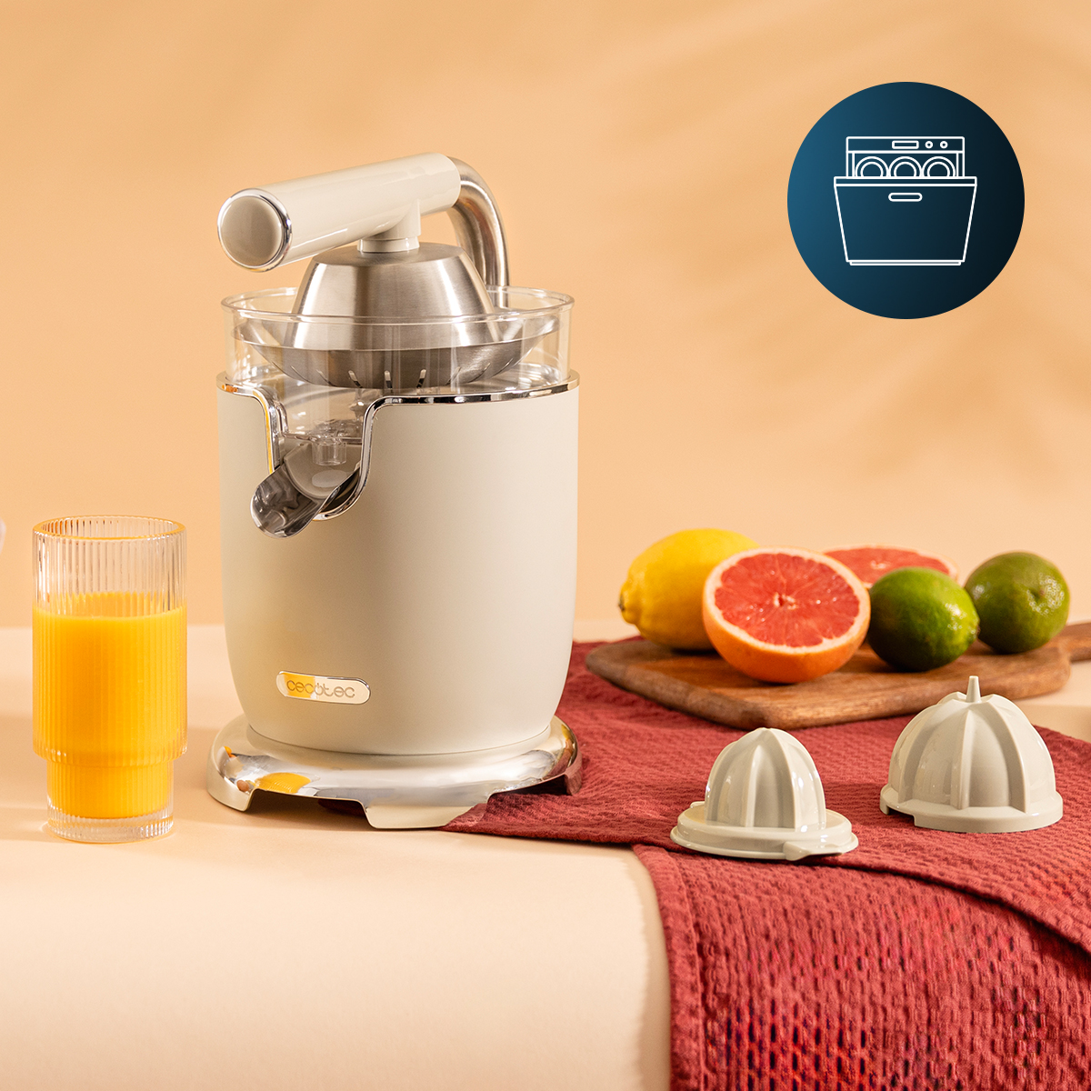 Spremiagrumi beige con succo, frutta fresca e due coni su un panno rosso.