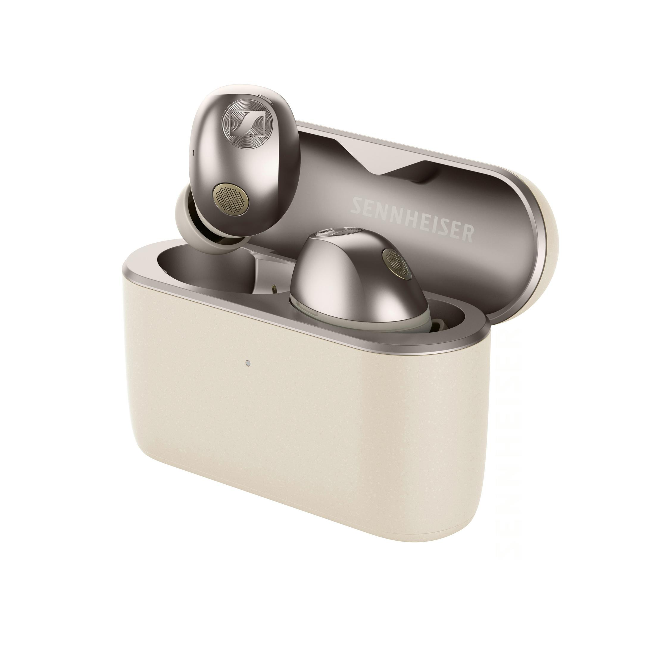Auriculares inalambricos Sennheiser en un estuche de carga beige abierto con detalles plateados.