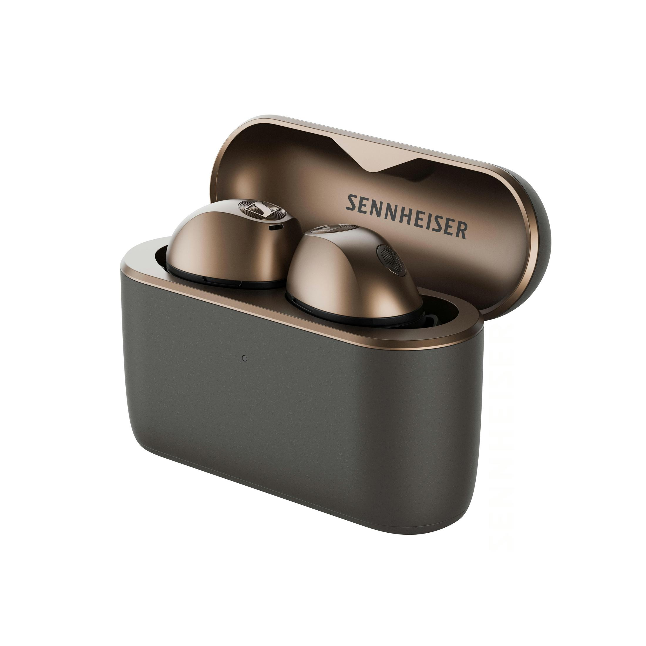 Estuche de carga Sennheiser gris oscuro abierto con auriculares de bronce brillante sobre fondo blanco.