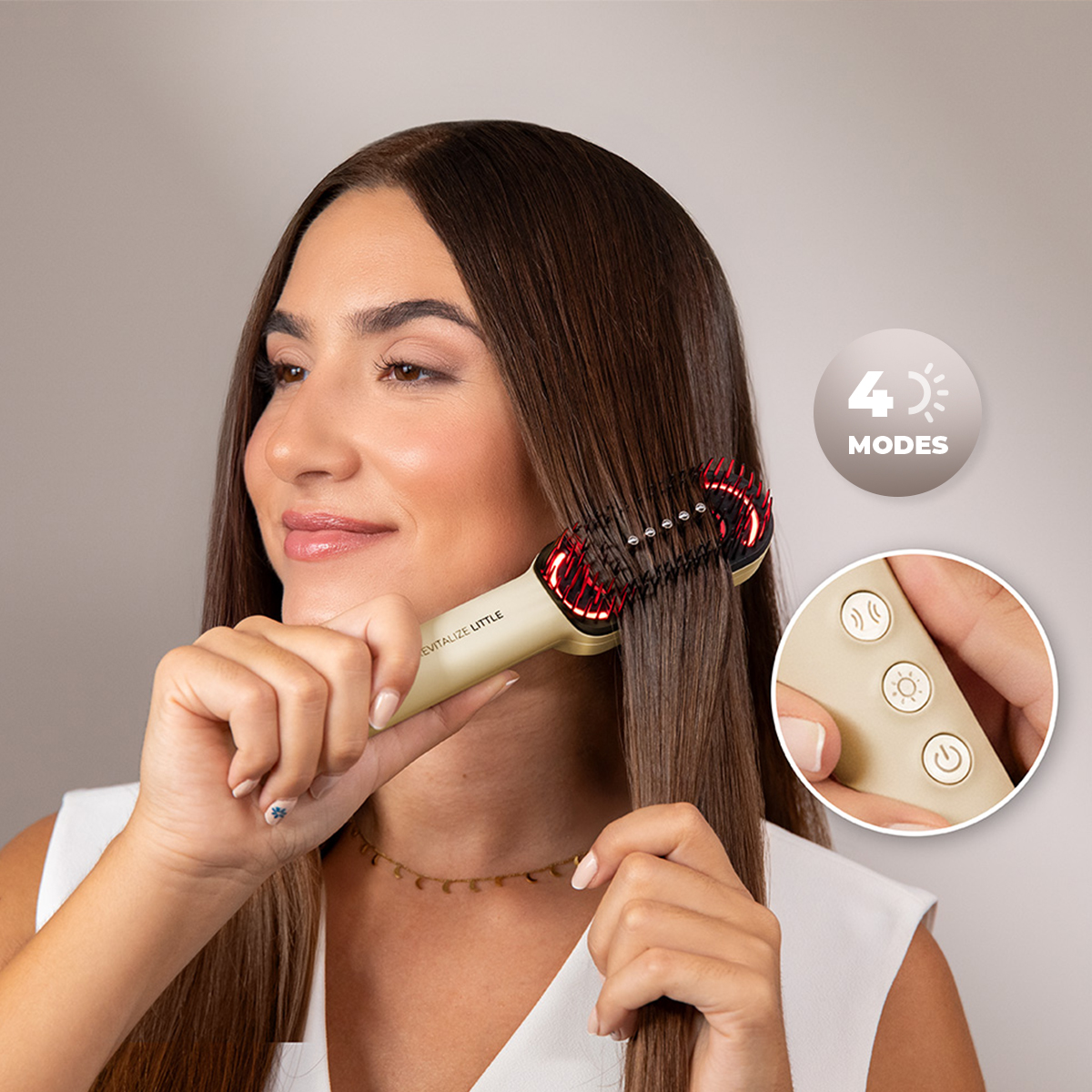 Una mujer sonríe mientras cepilla su largo cabello castaño con un cepillo dorado, con primer plano de los botones.