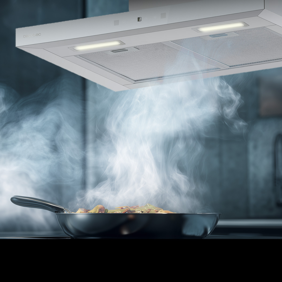 Una campana extractora absorbe el vapor que sale de una sartén con comida en la estufa.