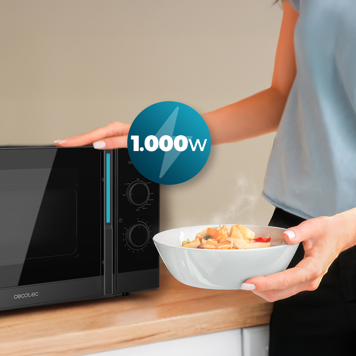 Una mujer sostiene un plato de comida caliente junto a un microondas negro con un icono de 1.000W.
