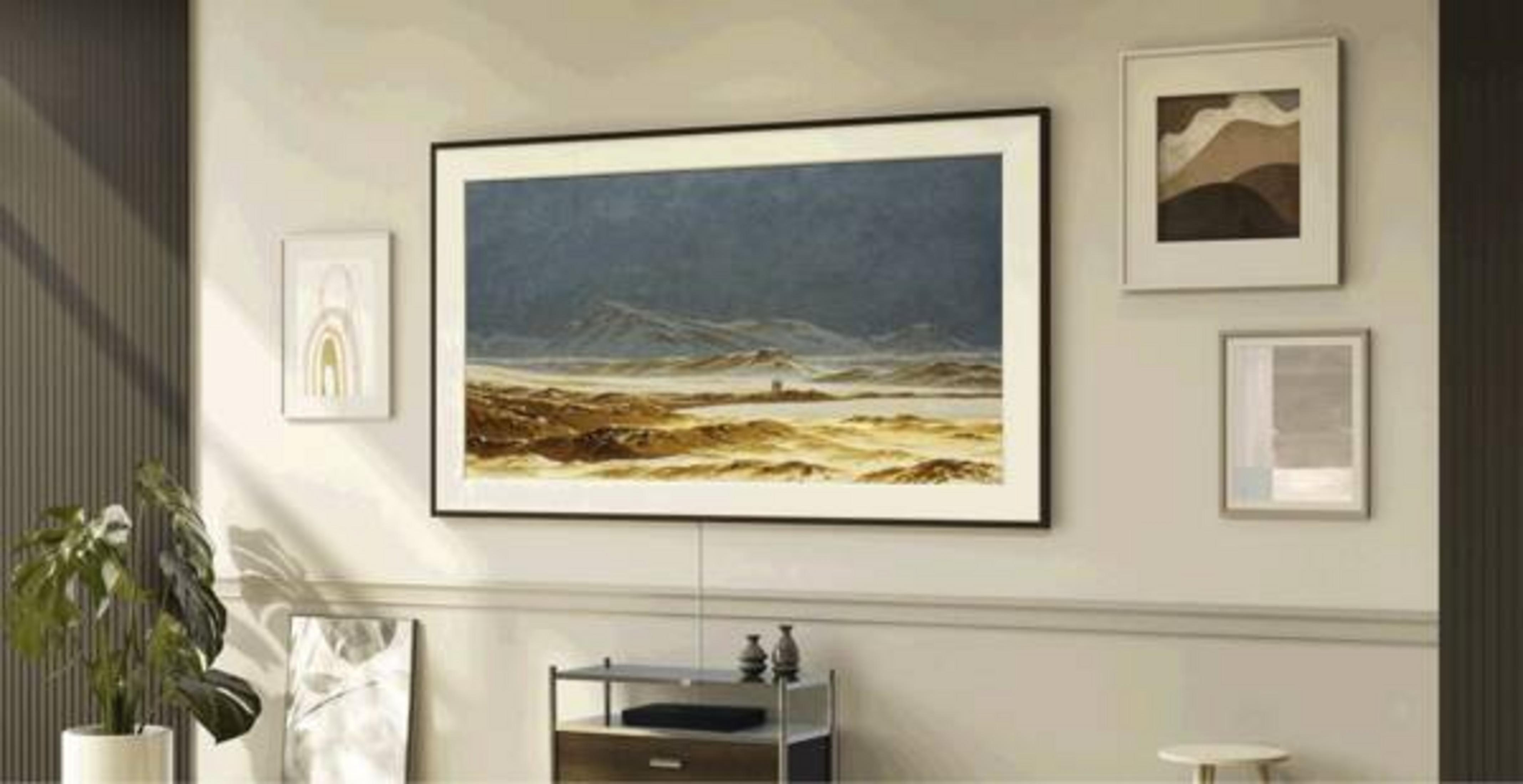 Un téléviseur sans cadre affiche un paysage, entouré d'art encadré sur un mur beige avec une plante.