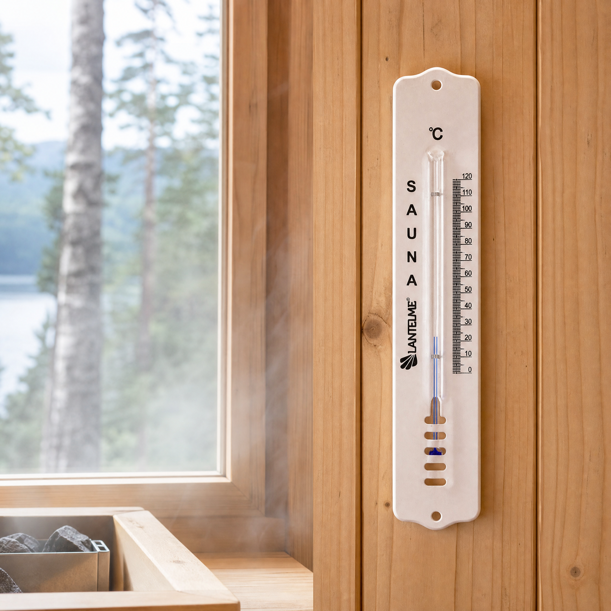Ein Saunathermometer an Holzwand neben Fenster mit Dampf.