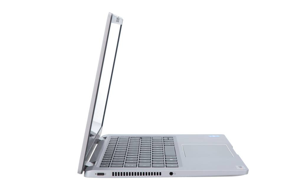 Widok z boku srebrnego laptopa na białym tle, z widoczną klawiaturą i otwartym ekranem.