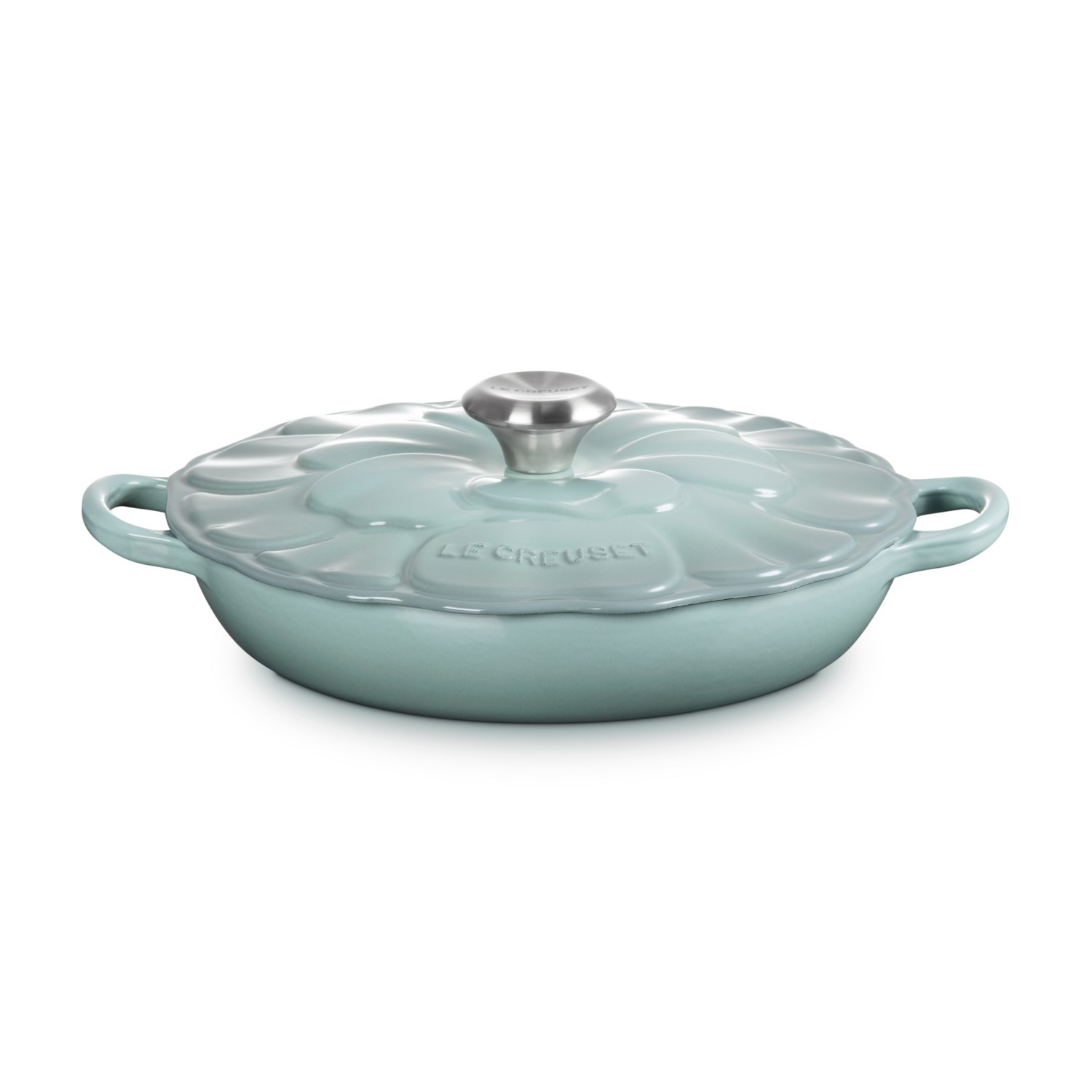 Poêle Le Creuset bleu clair avec couvercle floral sur fond blanc.
