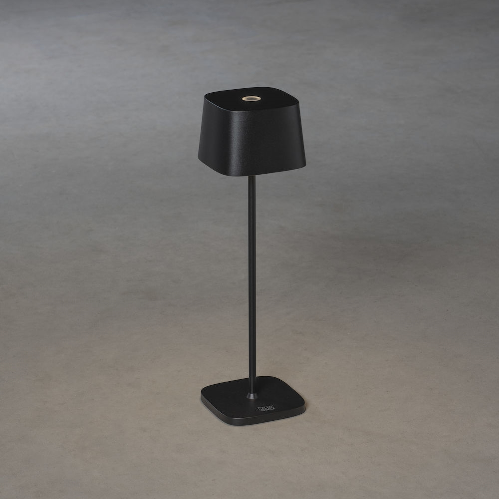 Eine elegante schwarze Tischlampe mit quadratischem Schirm und Fuß auf grauem Hintergrund.