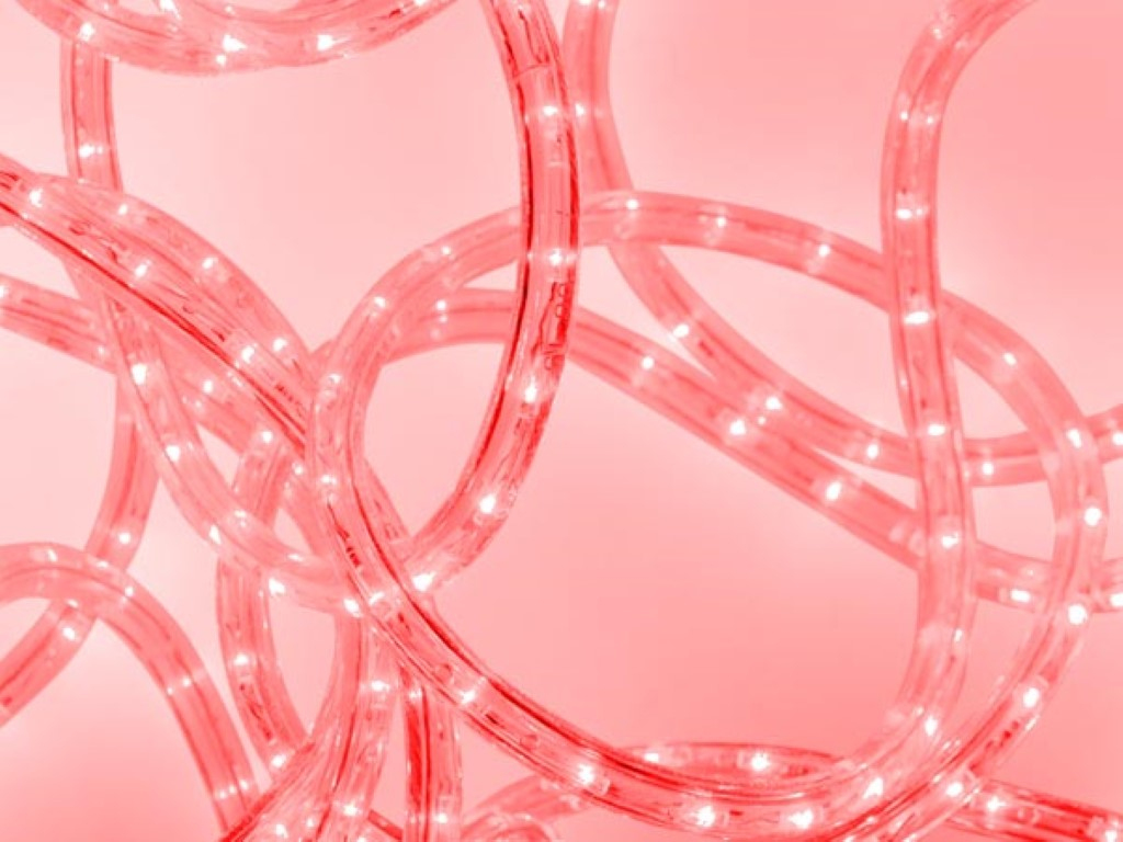 Strisce LED rosa aggrovigliate che brillano su sfondo rosa.