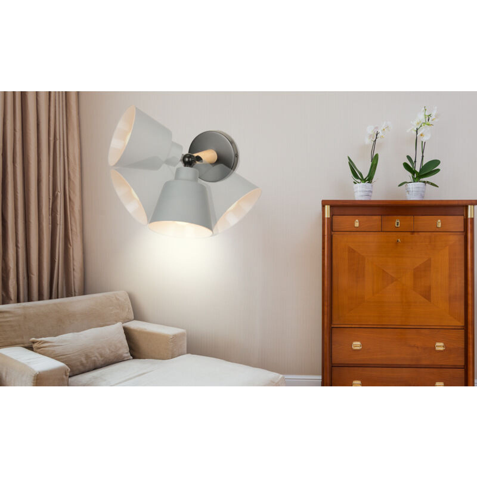 Wandlampe mit vier grauen Schirmen in einem Wohnzimmer mit Sofa und Holzkommode.
