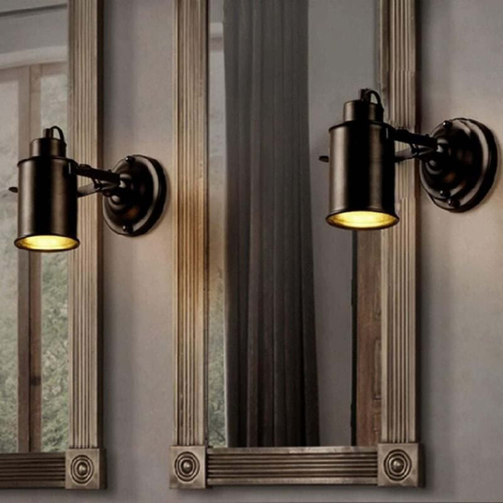 Zwei schwarze Wandleuchten mit warmem Licht sind an einer Wand neben gerahmten Spiegeln montiert.