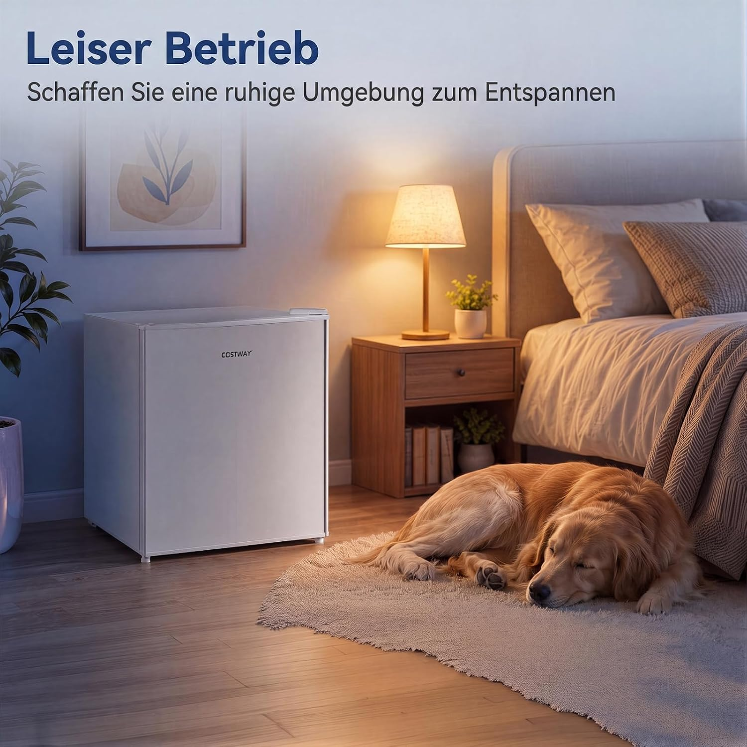 Ein kleiner weißer Kühlschrank steht in einem ruhigen Schlafzimmer, während ein Hund auf dem Teppich schläft.