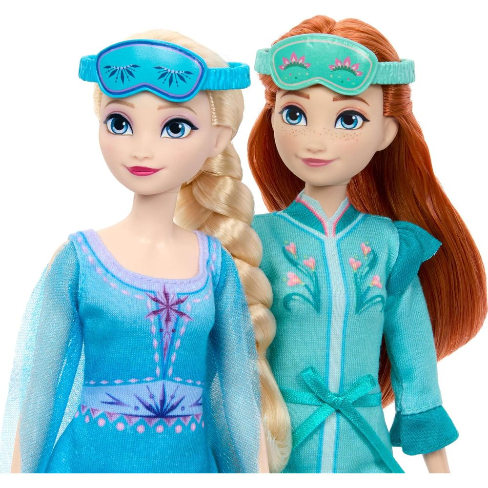 Muñecas de Elsa y Anna con pijamas azul y verde y antifaces para dormir a juego.
