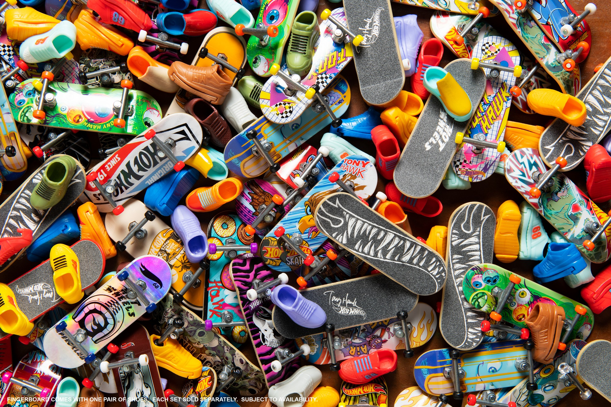 Un montón colorido de varios fingerboards y zapatos pequeños a juego en una superficie.