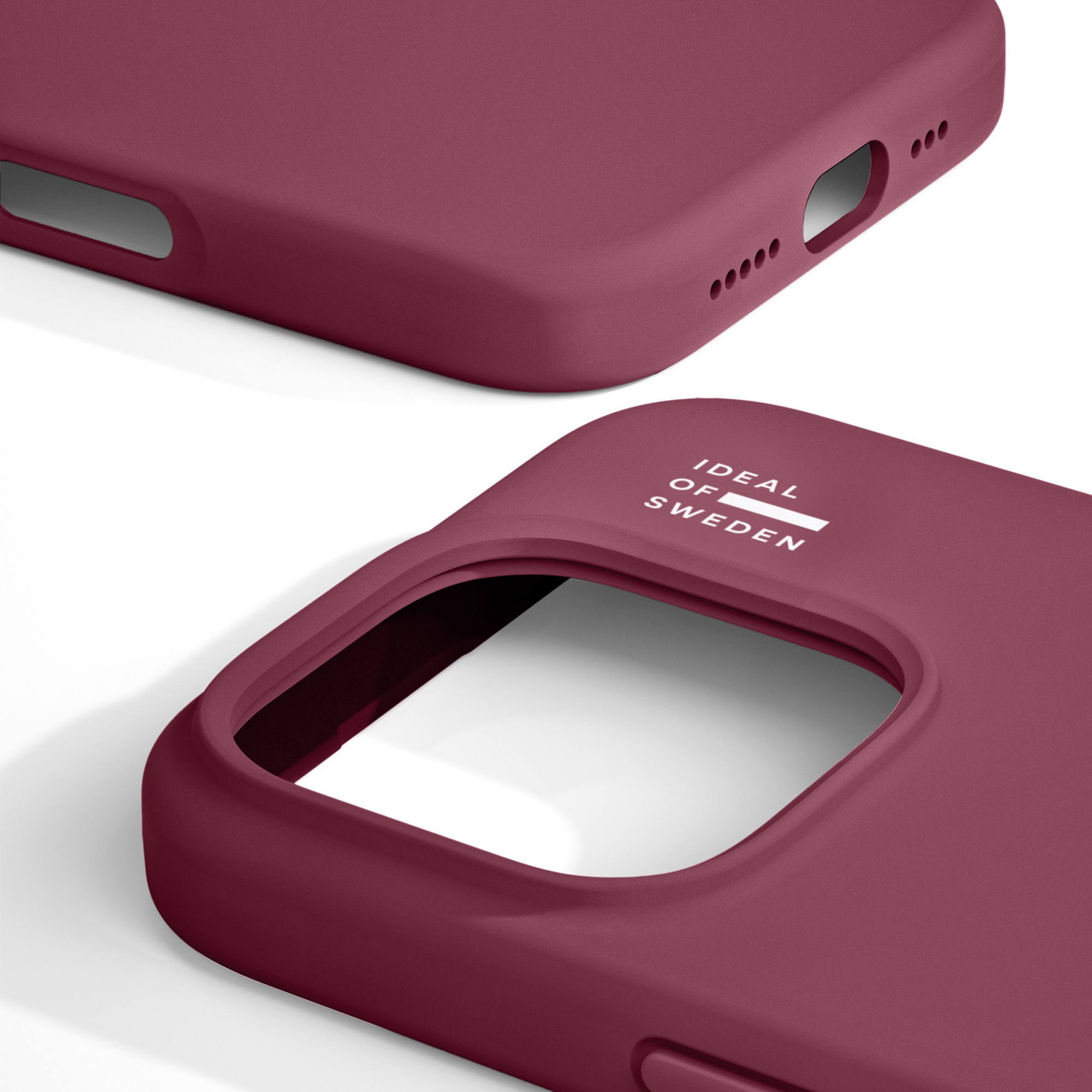 Two burgundy smartphone cases by Ideal of Sweden on a white background.