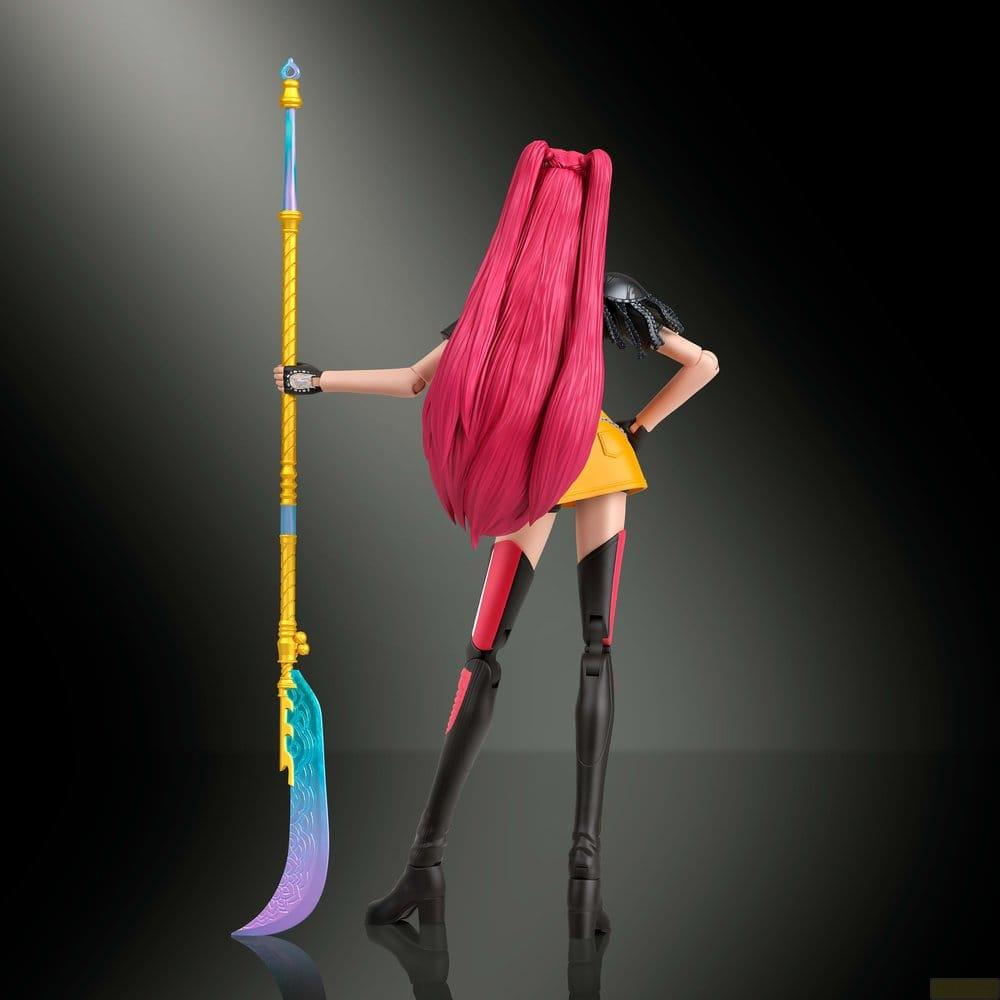 Vista trasera de una figura de acción con largo cabello rosa, sosteniendo un arma de asta azul sobre fondo oscuro.