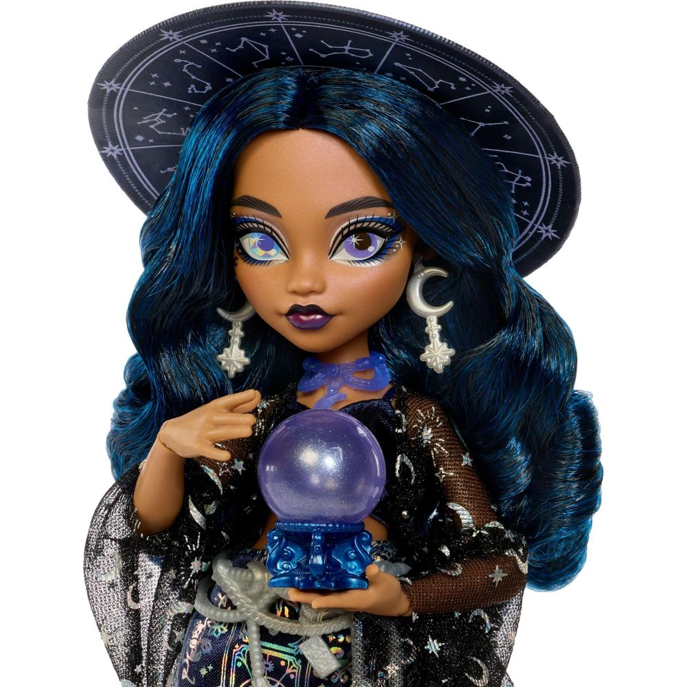 Una muñeca con cabello azul, sombrero de estrellas y una bola de cristal.