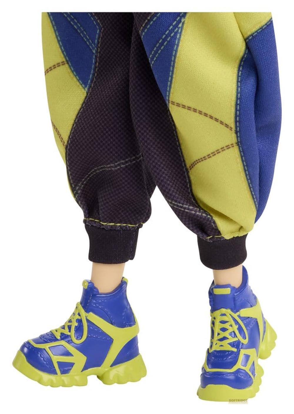 Piernas de muñeca con pantalones azules y amarillos y zapatillas azules con suelas verdes sobre fondo blanco.