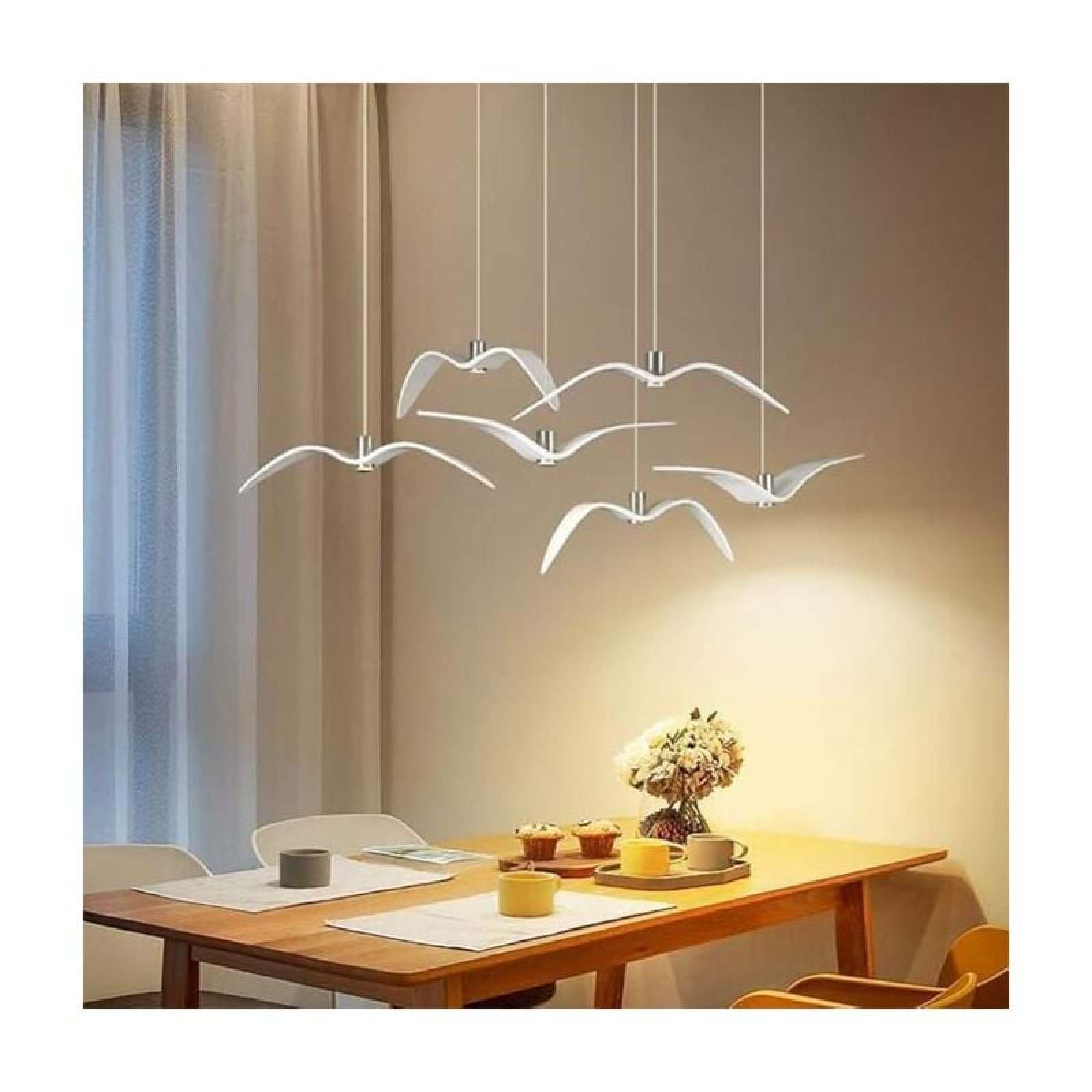 Moderne Hängelampen in Vogelform über einem gedeckten Holztisch in einem Esszimmer.
