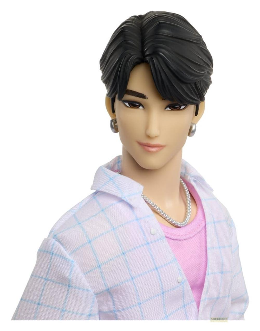 Primer plano de una muñeca de moda masculina con cabello negro, aretes y camisa a cuadros sobre una camiseta rosa.