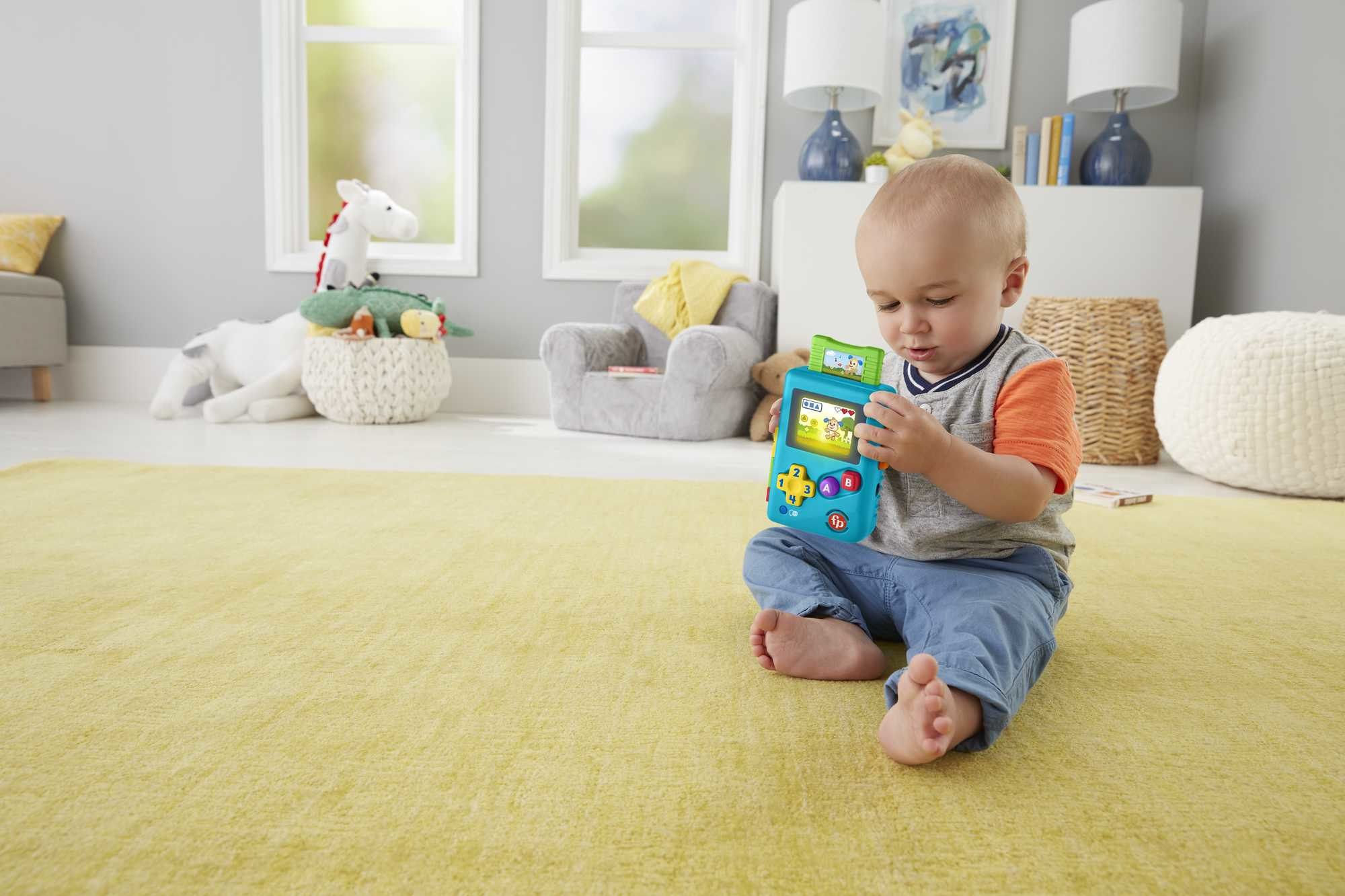 Niño pequeño sentado en una alfombra amarilla, jugando con un juguete colorido en una habitación luminosa.
