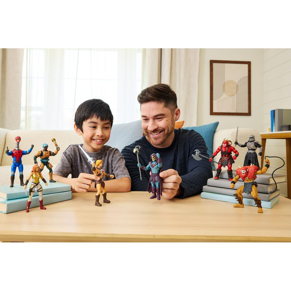 Un padre y su hijo juegan con figuras de acción en una mesa.