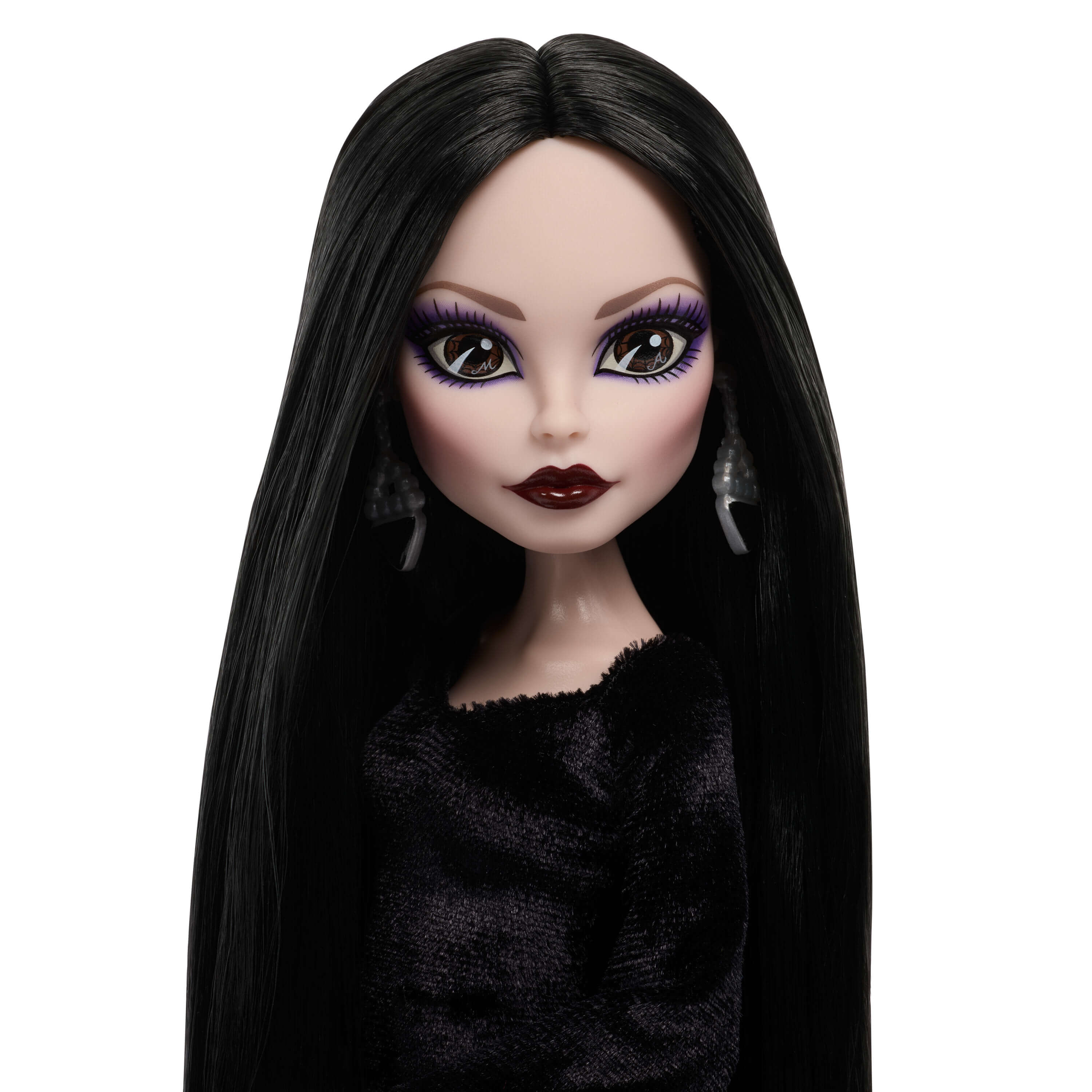 Primer plano de una muñeca de moda con pelo negro largo, sombra de ojos morada, labios rojo oscuro y top negro.