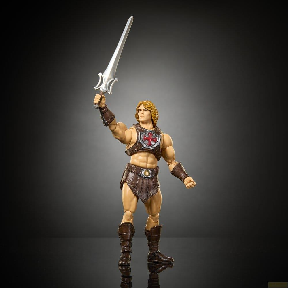 Figura de acción musculosa con cabello rubio, armadura marrón y una espada plateada levantada sobre fondo oscuro.