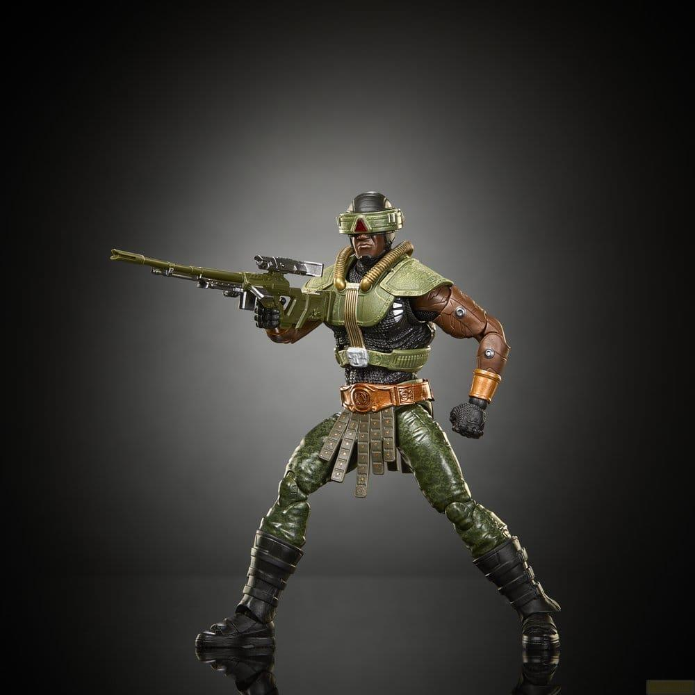 Una figura de acción con armadura verde y casco sosteniendo un rifle sobre fondo oscuro.