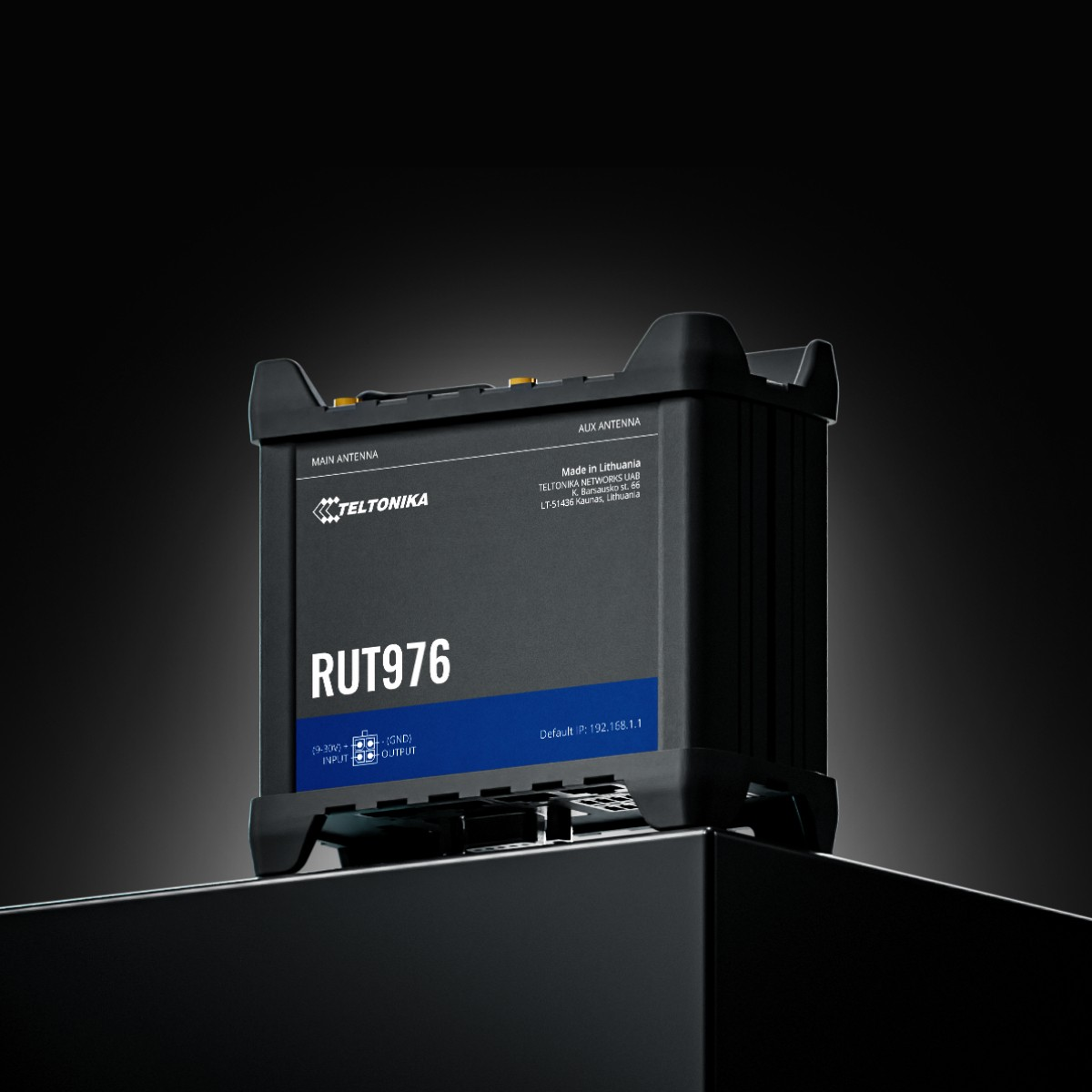 Un router Teltonika RUT976 negro descansa sobre una superficie oscura y brillante contra un fondo oscuro.