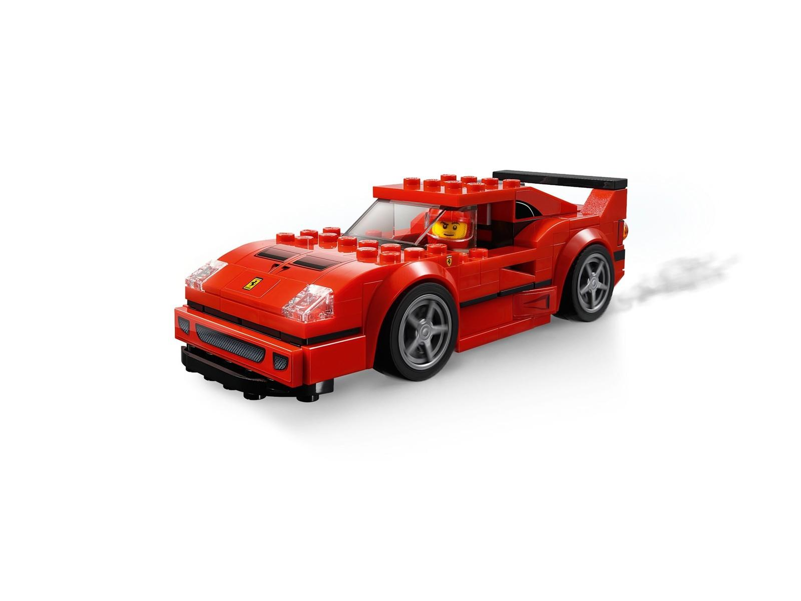 Ein rotes Lego-Spielzeugauto mit einem Fahrer im Cockpit auf weißem Hintergrund.