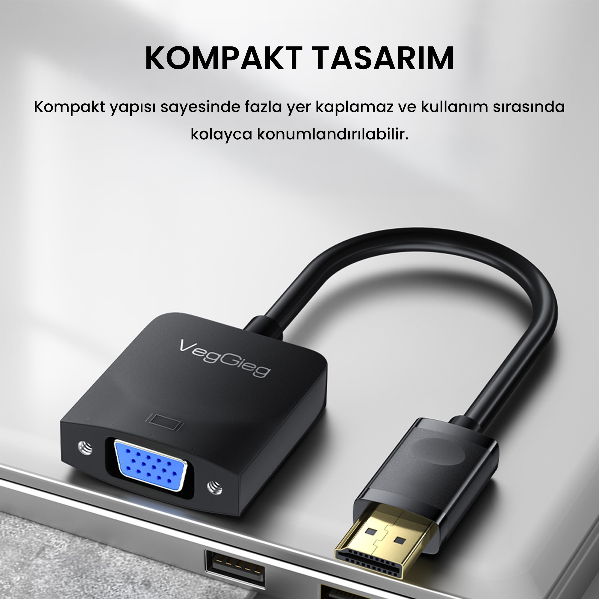 Gümüş renkli laptop üzerinde siyah VegGieg HDMI - VGA adaptör kablosu.