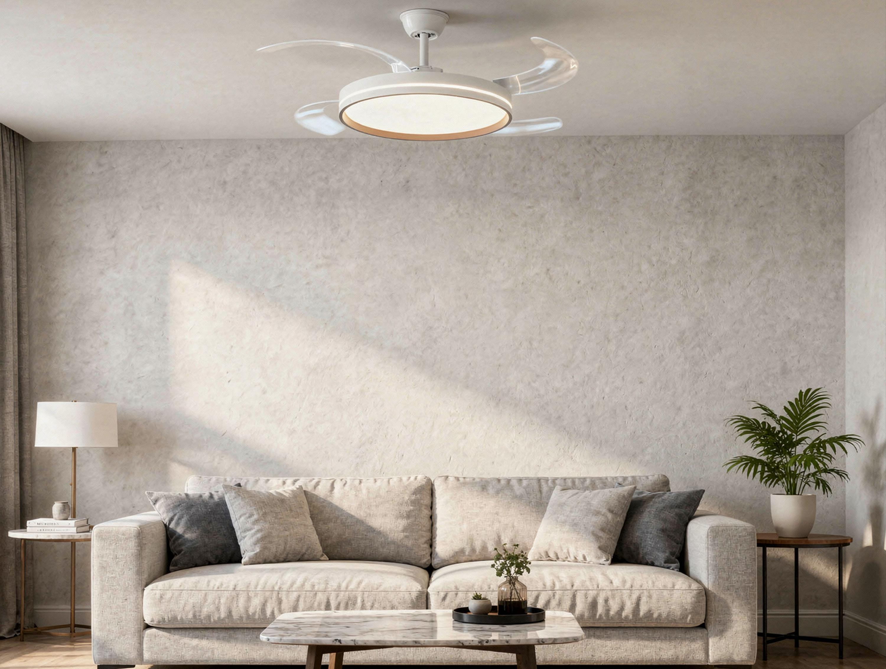Sala de estar con sofá claro, cojines, planta, mesitas auxiliares y una moderna lámpara de ventilador de techo.