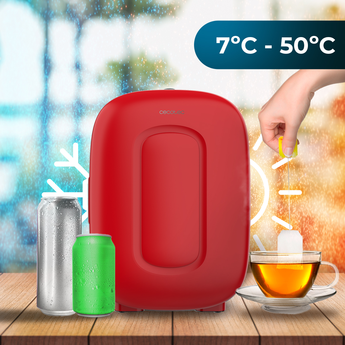 Un mini frigo rosso su legno, circondato da bevande, una tazza di tè e un indicatore di temperatura da 7°C a 50°C.
