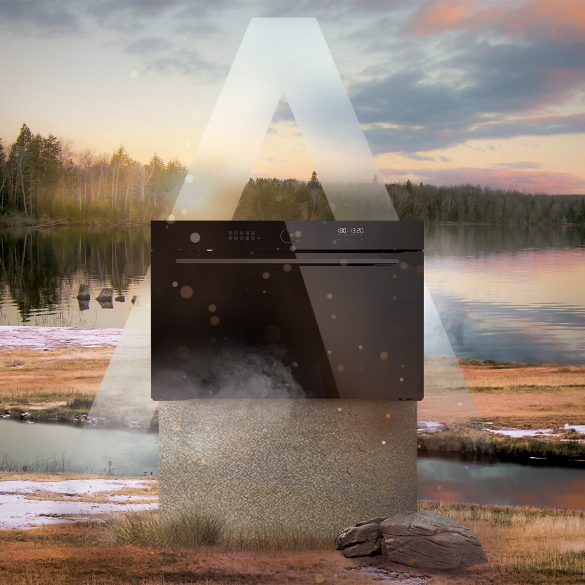 Un horno negro sobre un pedestal frente a un paisaje fluvial idílico al atardecer.