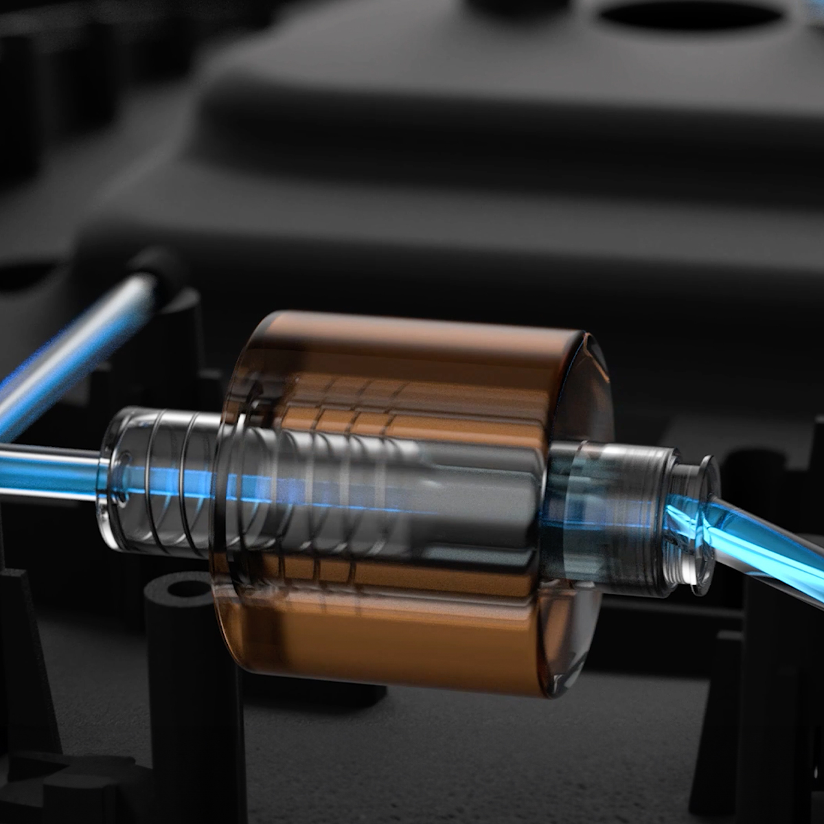 Un componente tubolare con liquido blu che scorre nel meccanismo interno su sfondo scuro.