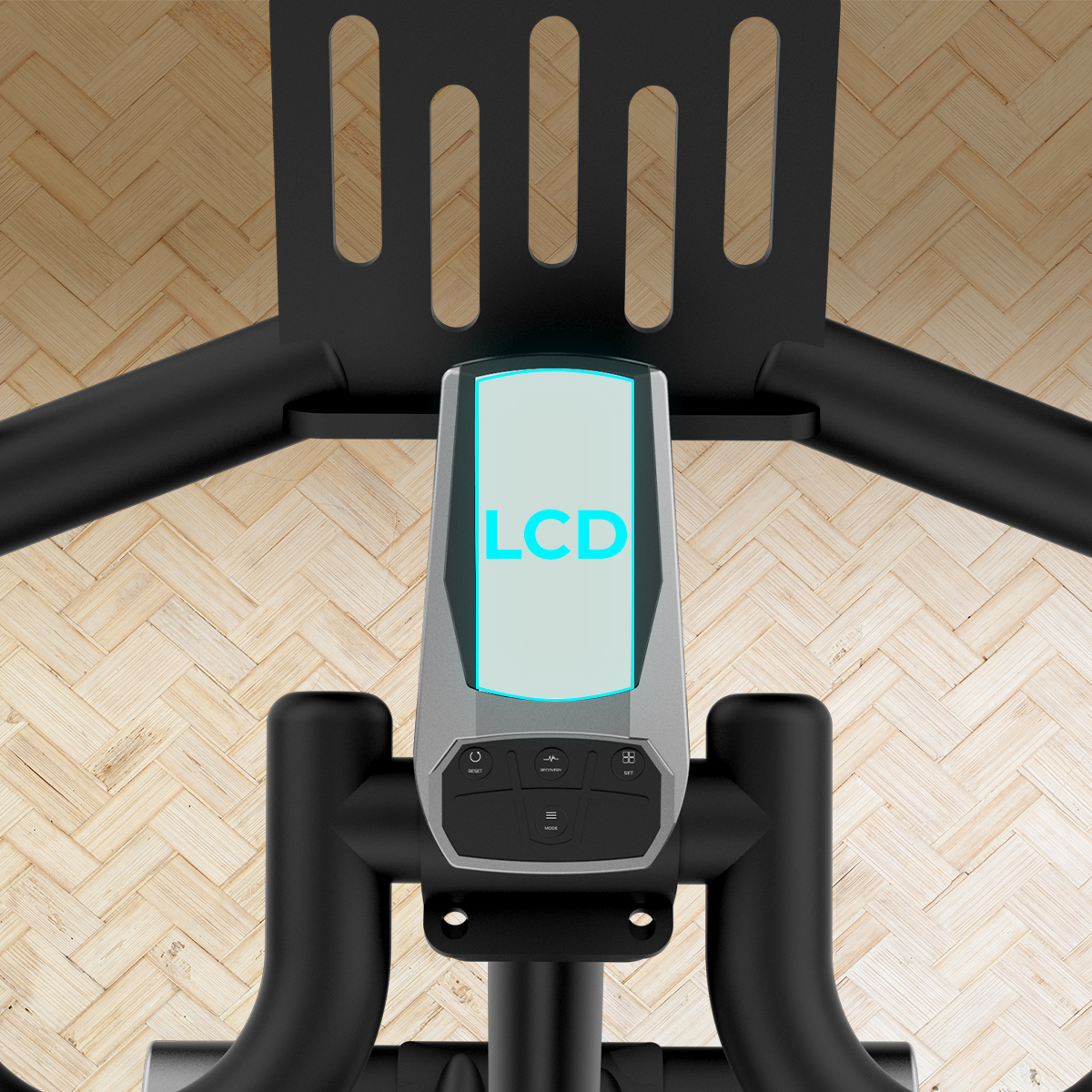 Primer plano de la consola de bicicleta estática con pantalla LCD y manillar sobre suelo de madera.